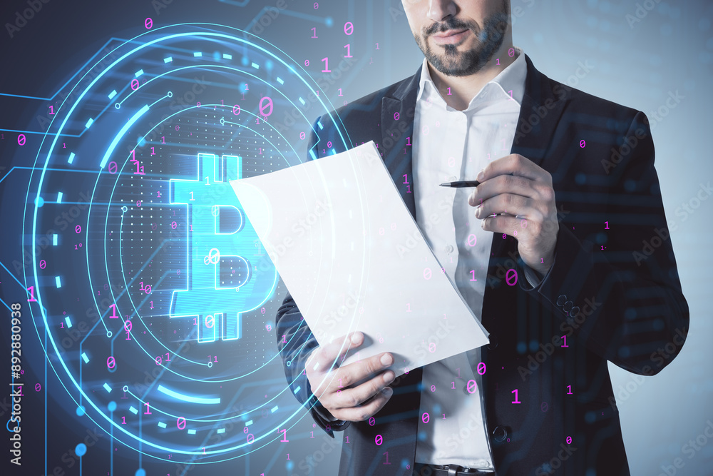 Poster attractive half-headed businessman editing document with digital bitcoin sign on blurry background. 