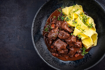 Traditionelles deutsches geschmortes Hirschragout mit Gemüse und Tagliatelle Pasta in süß...