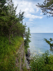 View over Lake Ontario with trees on a cliff high above the water at Robert G. Wehle State Park in New York state, USA.