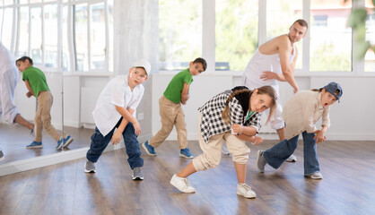 Positive girls and boys training hip hop in dance studio, dance classes for kids