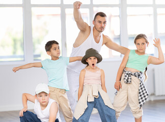Fototapeta premium Group of preteen boys and girls hip hop dancers posing in a dance studio