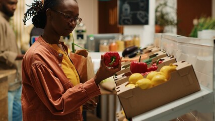 Shopper choosing freshly harvested vegetables from market, eating healthy and buying produce from...