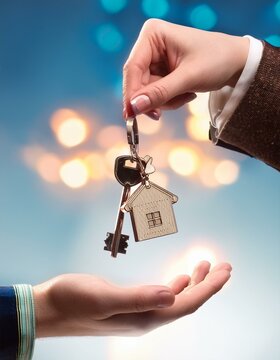 trousseau de clef avec porte clef en forme de maison donn&eacute; d'une main &agrave; une autre en ia