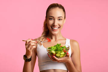 Sport And Diet. Cheerful Fitness Girl Eating Vegetable Salad Standing In Studio Over Yellow...