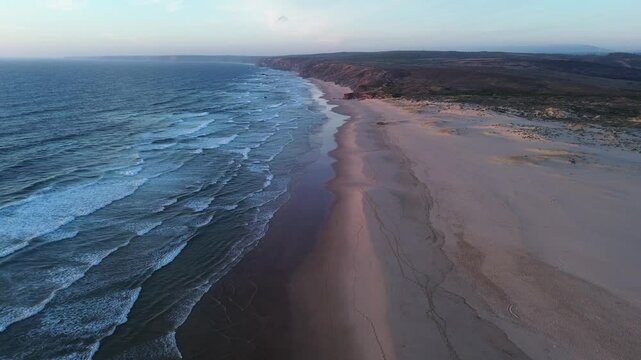 Sunset at wild beach Praia da Bordeira in Portugal aerial view