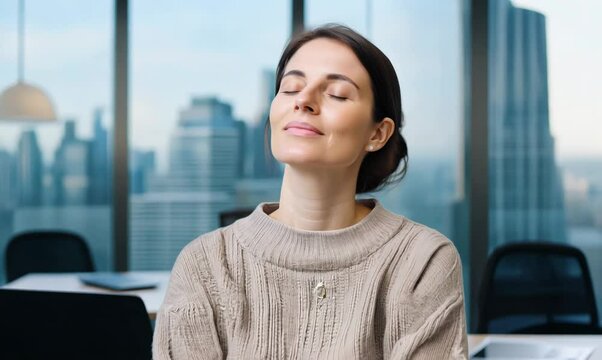 Group portrait video of a woman in her 40s practicing mindfulness sophrology relaxation & stress-reduction wearing a cozy sweater against an office or corporate background