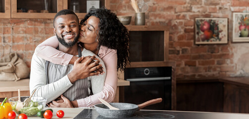 Portrait of lovely african american couple embracing at kitchen, copy space