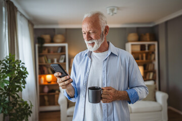 portrait of senior man stand hold cup of coffee and use mobile phone