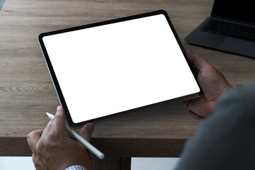 A businessman holds a mockup. iPad digital tablet with blank screen Mockup replaces your design mockup in the office.