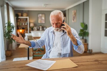Senior man sit at home have a phone call while receive bad report