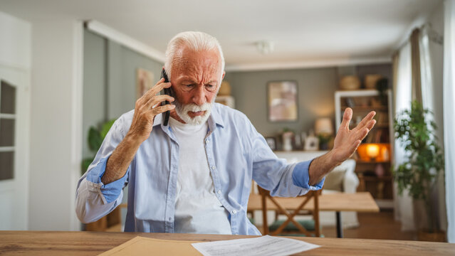 Senior man sit at home have a phone call while receive bad report
