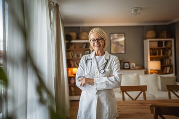 Portrait of mature woman doctor stand and smile at home