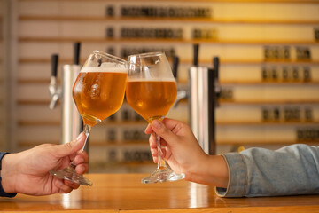 Cheers with craft beer: a toast in a modern bar.