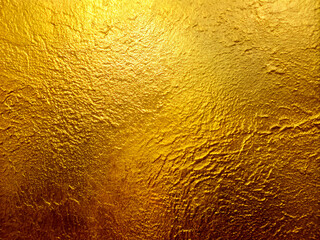 Naklejka premium texture, Gold wall texture background. Yellow shiny gold foil paint on wall sheet with gloss light reflection, vibrant golden paper luxury wallpaper
