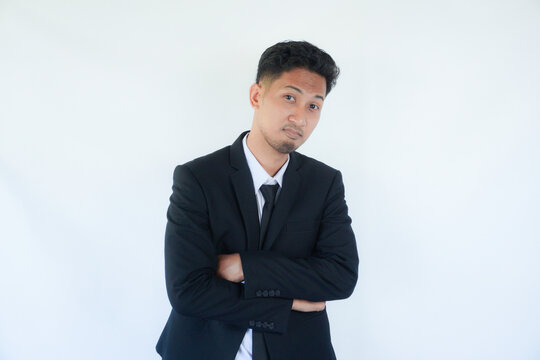 Adult Asian man wearing black suit and tie showing fierce face with his hands on hip