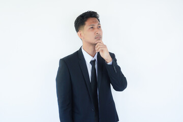 Asian businessman thinking about something while looking to upper right corner