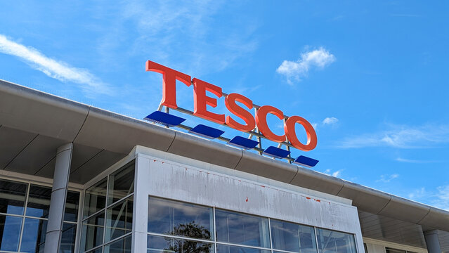 Tesco supermarket sign against blue sky, multinational groceries and general merchandise retailer in Shepton Mallet, Somerset, England taken on 22 June 2024