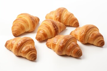 six croissants placed on a white table.