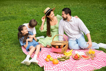 Happy family having picnic together in park