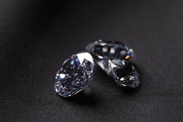 Many beautiful shiny diamonds on black fabric, closeup