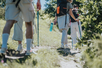 Group of friends enjoying a hike together in the mountains. Trekking poles and backpacks in use as they explore the scenic trail.