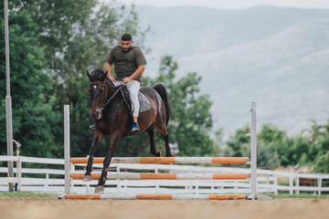 Man riding horse jumping over an obstacle in an outdoor equestrian competition, showcasing...