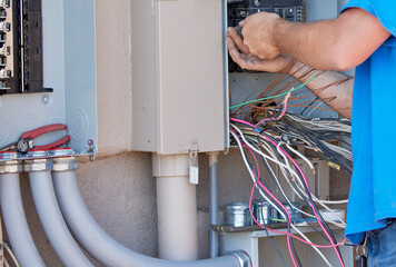 Electrician installing a transfer panel for a whole house generator