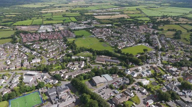 Aerial orbital view of Holsworthy, featuring the Church of England Primary School and surrounding residential streets