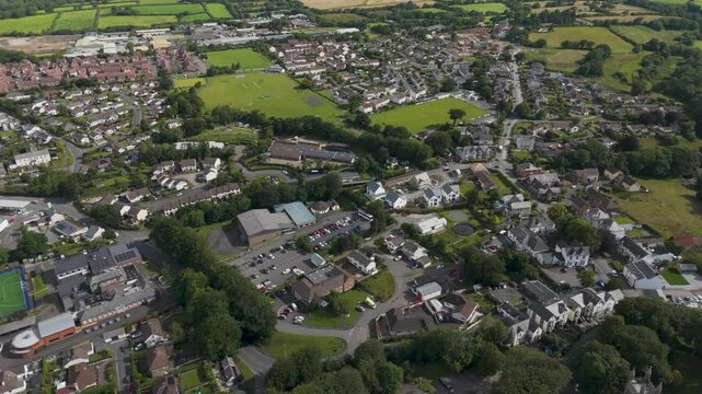 Drone rising view of Holsworthy, showcasing the Church of England Primary School and residential streets