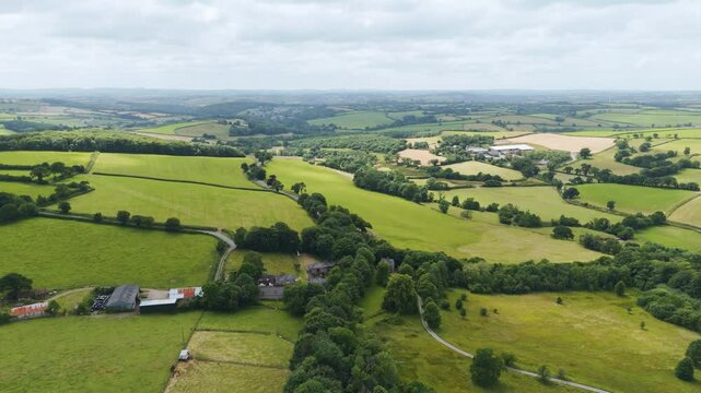 Drone view of the rural Devonshire countryside during a hot summer, showcasing the expansive green fields and natural beauty