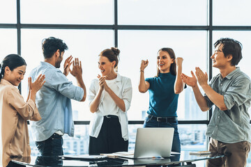 Portrait of diverse professional start up project team celebrate their project. Group of business people clapping hand, high five, cheer up for celebrating new product on table with laptop. Tracery.