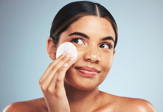 Woman, cotton pad and skincare for face cosmetics, aesthetic spa and thinking on studio background. Happy young model, beauty and facial dermatology product for cleaning makeup, shine and cosmetology