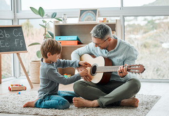Education, guitar and father teaching son how to play instrument on floor in living room of home. Family, lesson or music with single parent man and boy child in apartment for learning or study