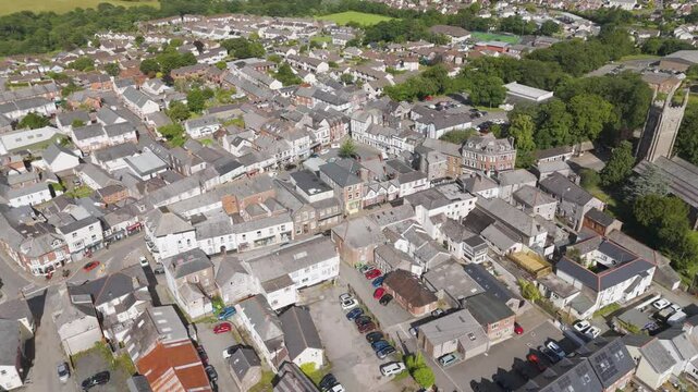Aerial orbital view of Holsworthy town centre on a summer afternoon, featuring its vibrant streets and historic architecture, Devon, United Kingdom