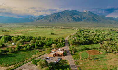 Country road, farmland and mountain range in  Taos, New Mexico, United States Of America.