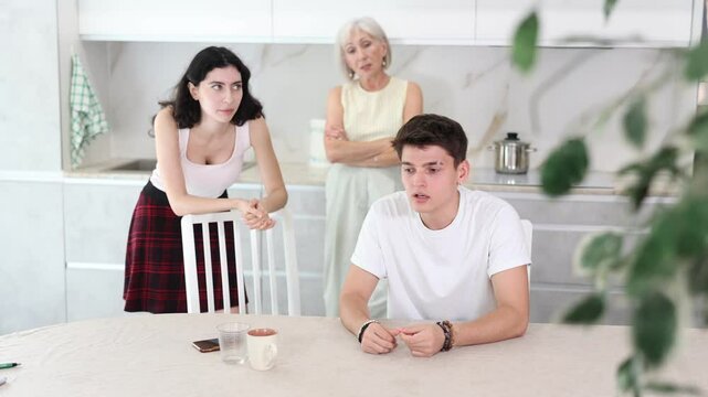 Upset and unhappy young son-in-law sitting in the kitchen separately, family conflict. High quality 4k footage