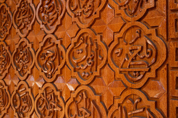 Arabic calligraphy of Allah's names in wood carvings, mosque decoration wooden doors
