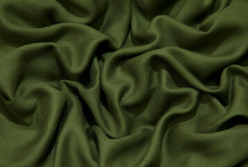 Green fabric background. Green cloth waves background texture. Green fabric cloth textile material.