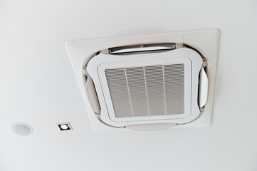 Ceiling-mounted air conditioner with integrated light and speaker, showcasing modern HVAC design.
