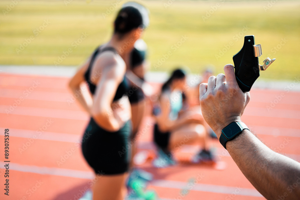 Sticker Hand, race and fire starter gun for running or exercise with athlete on track. Starting pistol, group or women at stadium field to get ready for training, cardio or sprint competition closeup outdoor