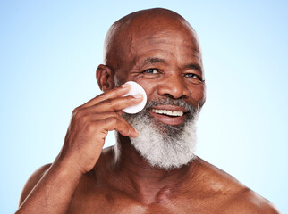 Black man, portrait and skincare in studio with cotton pad for cleaning, toner and skin moisturizer. Mature person, face and dermatology on blue background with beauty swab for wellness or treatment