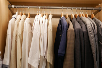 An organized closet showcasing neatly hung shirts and jackets on wooden hangers
