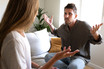 Young caucasian man having an argument with wife. Woman is angry with man.