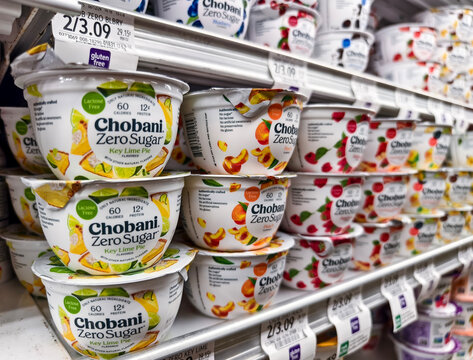 Variety of Chobani yogurt on supermarket shelf with price labels