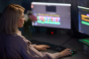 Professional Video Editor Working Late on Advanced Editing Software in Home Office