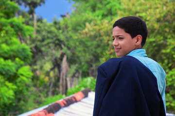 an indian school boy hold their school court and giving pose