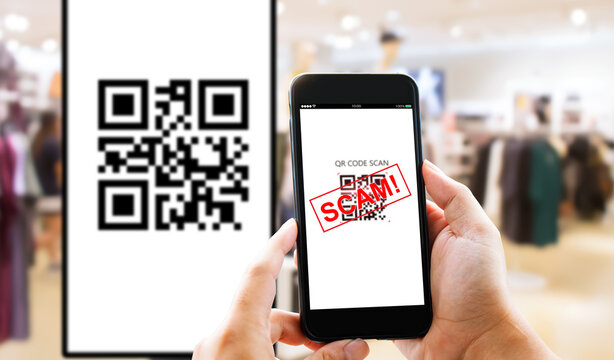 Fake QR Code scams fraud phishing concept. Man hands using smart phone