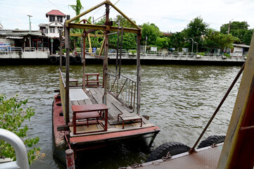 Obraz premium BANGKOK, THAILAND - July 29, 2024 : Wooden raft and iron fence for crossing the Saen Saep Canal and hoisting with slings at Bangkok, Thailand.
