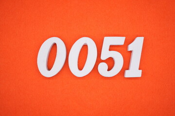 The numbers are made of white painted wood. Placed on the floor was orange paper.