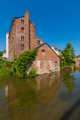 Louviers, France 07 19 2024 : Red brick building along the Eure river in the Center of Louvier in Normandy